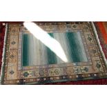 Large Oriental style rug, fringed, central panel in pale green and cream, with decorated border,