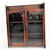 Dwarf oak three-tier enclosed bookcase with glass panelled doors