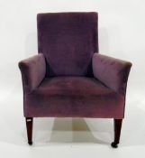 Edwardian upholstered square-back easy chair on square tapering supports and ceramic castors