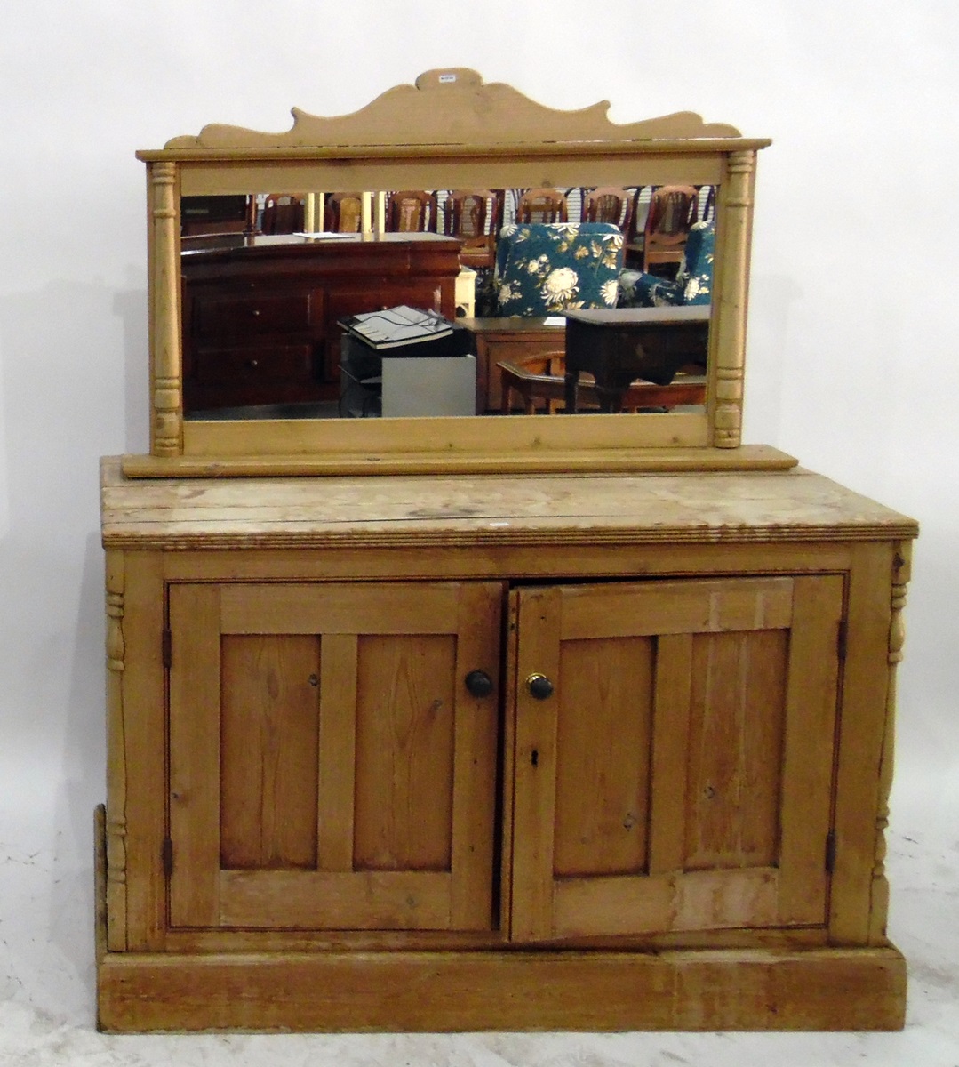 Pine cupboard enclosed by two panelled doors, flanked by turned quadrant pilasters and on plinth