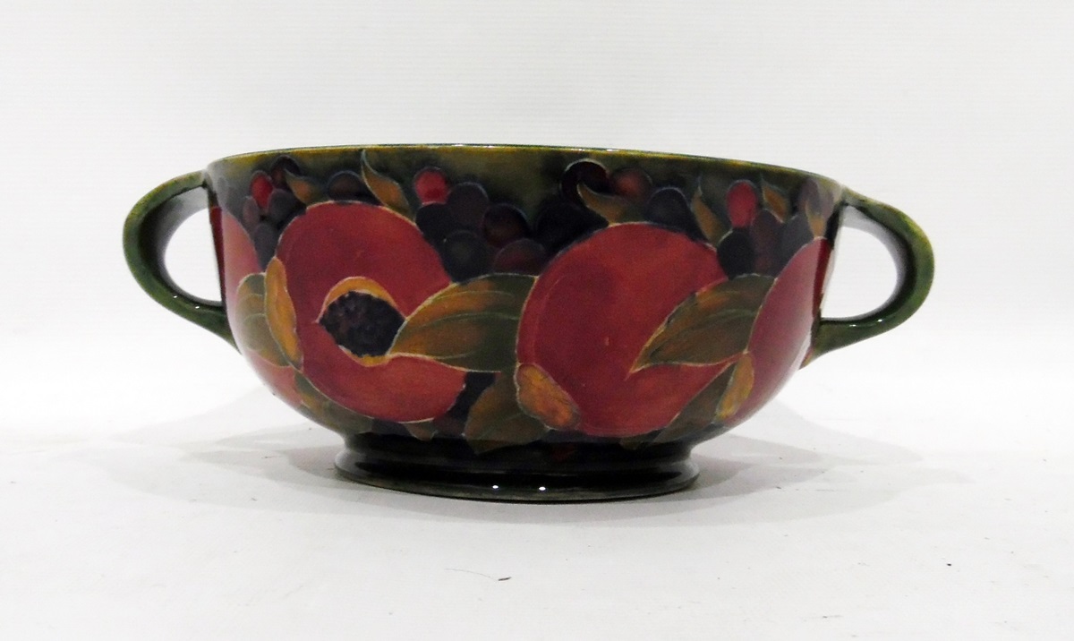 Early Moorcroft two-handled pottery bowl, 'Cut Pomegranate' pattern on a green ground, 26cm diameter