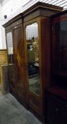 An Edwardian inlaid mahogany breakfront wardrobe having a centre panel flanked by two bevelled