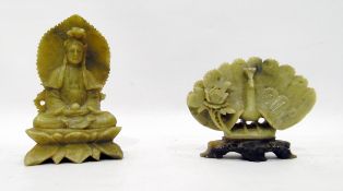 Carved jade figure of a seated deity, 11cm high and a carved jade model of a peacock with flower, on