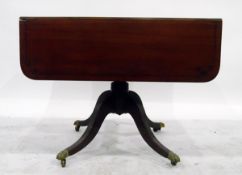 Georgian style mahogany drop-flap pedestal table on quadruped splayed reeded legs with brass paw