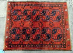 Persian style wool rug, the red ground with two rows of quartered elephant foot guls, stylised