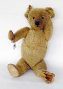 Early 20th century plush bodied teddy bear with movable arms and legs, having distinctive bent paws,