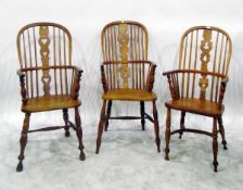 Set of three elm and ash high spindle back elbow chairs with pierced splats, turned supports and