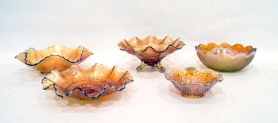 Five marigold Carnival glass bowls including one decorated with cherries on a tripod base, another