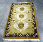 Wool carpet, the beige ground with cream, green and beige scroll medallions, 210cm x 126cm approx