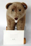Reproduction Steiff bear on wheels with growler, light brown, having button to ear and tag 'Bar 1921