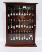Collection of silver coloured and plate souvenir spoons within a fitted glazed mahogany case