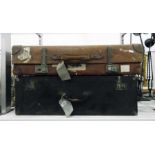 Large vintage leather suitcase bearing various tra