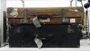 Large vintage leather suitcase bearing various tra