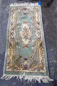 Chinese washed wool rug, pale green ground with oval medallion, allover floral and scroll decorated,