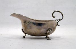 Silver sauce boat with reeded border, scroll handl