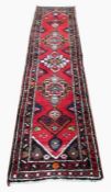 Persian wool runner, red ground with black, white and green borders, 265 cm x 65 cm