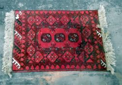 Persian wool rug, red ground with elephants guls and dark red border, 87 cm x 52 cm