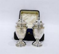 Pair of silver pepperettes with finial covers, of