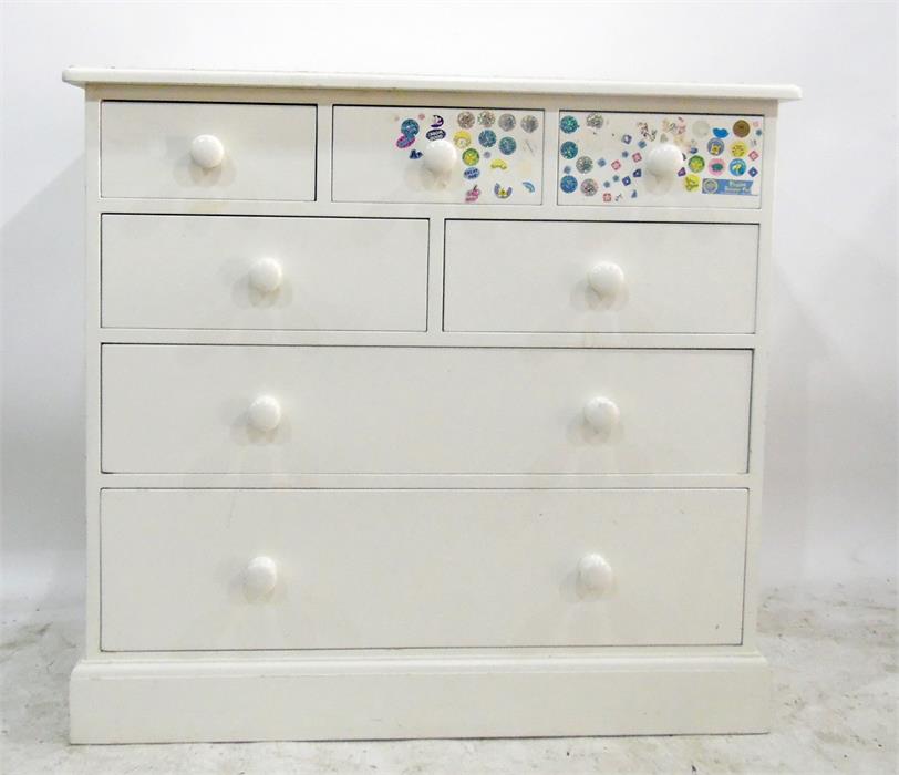 White painted pine chest of five short and two long drawers, with turned wooden knob handles, raised