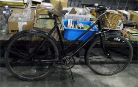 Lady's old bicycle with black metal frame, sit up and beg handle bars, basket and leather seat