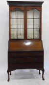 Georgian style walnut bureau/bookcase with blind fretwork frieze, the pair of arched panel glazed