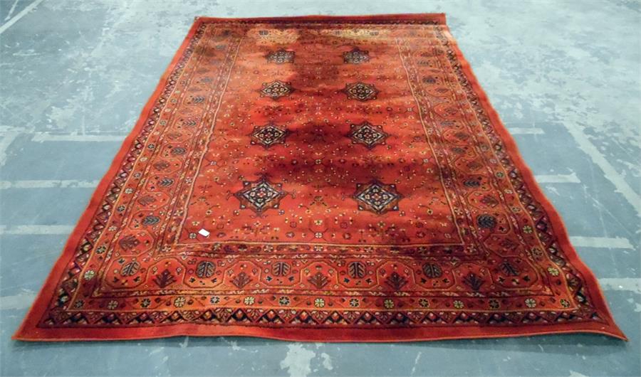 Persian style wool rug, red ground with striped border and lozenge pattern to centre, 292cm x 199cm