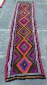 Suzni Kelim wool runner, multi-coloured with multi border and six lozenges to centre, 282cm x 69cm