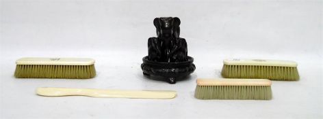 Carved ebony group of elephants on a Chinese stand, three ivory brushes and a shoe horn