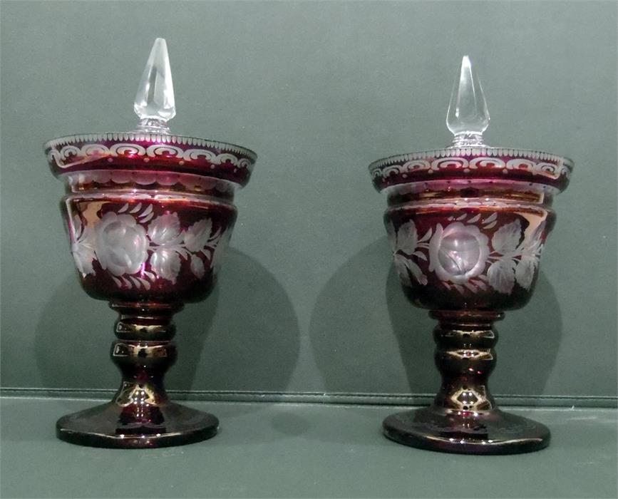 LOT WITHDRAWN Pair of Victorian cranberry glass pedestal lidded urns with clear glass finials,