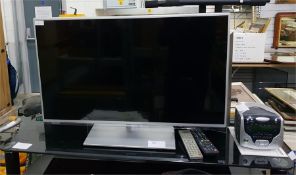 Panasonic flatscreen television with black glass and chrome television stand, a Compacks Kodak DVD