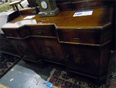 Oak sideboard with carved back of fruit, three drawers above three cupboards, on carved base,