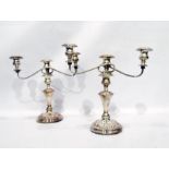 Pair of silver plated three-branch candelabrum, on turned column support, on circular plinth base,