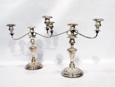 Pair of silver plated three-branch candelabrum, on turned column support, on circular plinth base,