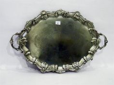 Large silver plated oval tray of shaped design with two handles, having engraved decoration to