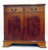 Reproduction mahogany veneer cupboard with moulded edge top, two frieze drawers, the pair of