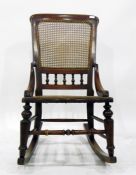 Early 20th century stained as mahogany cane panelled rocking chair with turned spindle gallery
