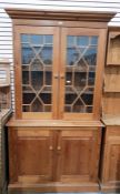 Pine bookcase on cupboard having flat moulded pedi