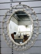 Oval bevelled plate wall mirror within a decorativ