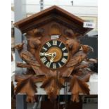 Old cuckoo clock with usual carved case and a carv