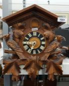 Old cuckoo clock with usual carved case and a carv