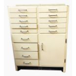 Cream painted dentist's cabinet with an arrangement of fourteen drawers and single cupboard, all
