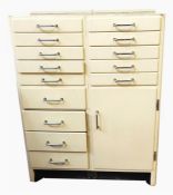 Cream painted dentist's cabinet with an arrangement of fourteen drawers and single cupboard, all