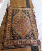 Persian style wool rug, the pink ground with multiple hooked lozenges, herati stylised border in