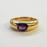 9ct gold and amethyst ring, the gold band set with oval cut amethyst in rubover setting