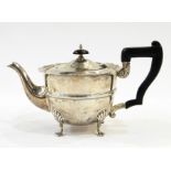 George V silver bachelor's teapot with ogee cut card borders and raised bands to the body, on tab