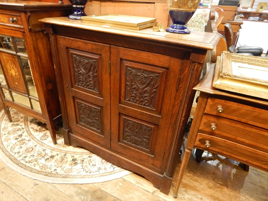 Carved oak side cabinet, having fluted fore-pillasters, bi-fold framed panelled door with foliate