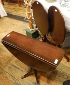 Two reproduction mahogany tilt-top tripod occasional tables with oval tops and a reproduction