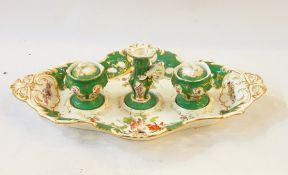 Victorian porcelain inkstand comprising two inkwells and a candlestick, all within a rococo style