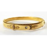 Victorian 15ct gold bangle of buckle-type design, applied bead and scroll border and inset brilliant