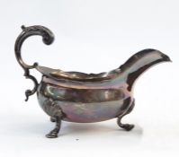George III silver sauce boat, oval with cut card border and free C-scroll handle, raised on three